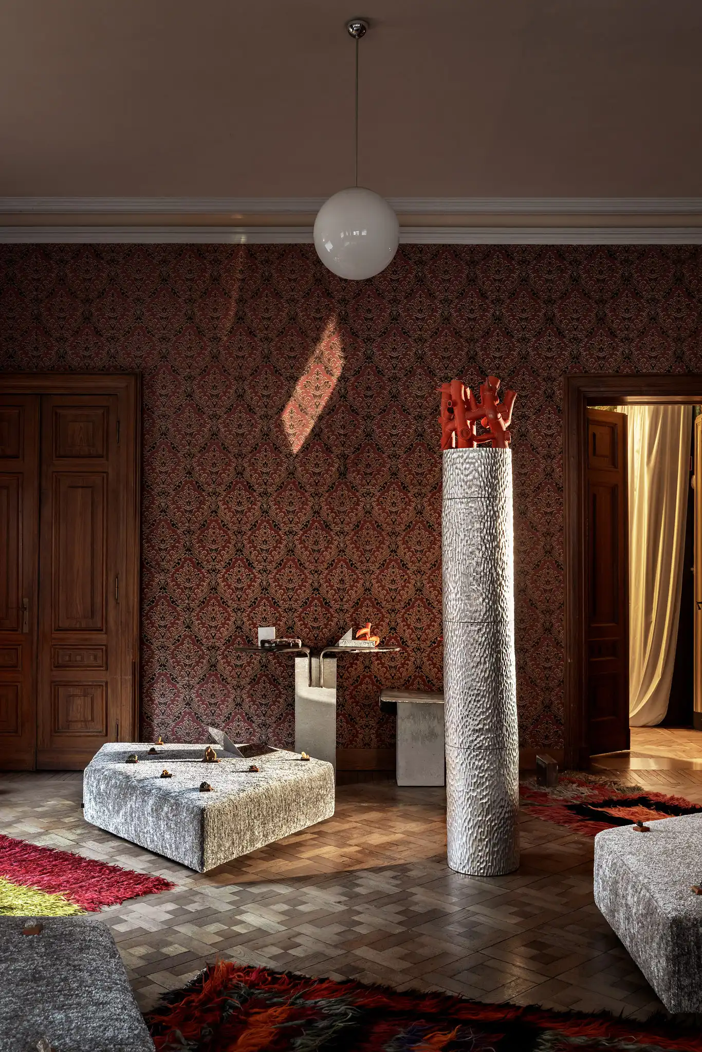 Allestimento di un living room con divano modulare contemporaneo e elementi artistici in ceramica