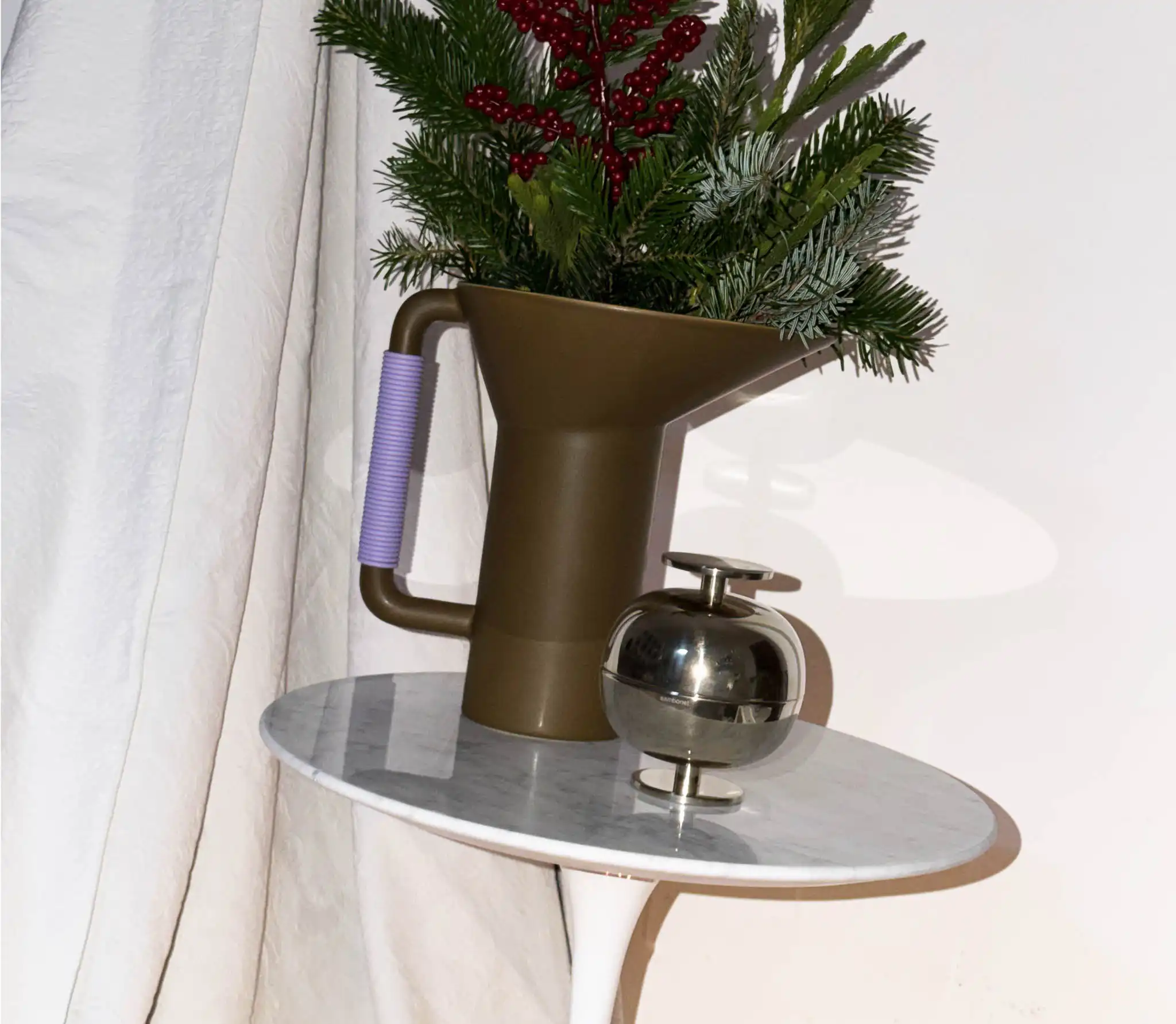 allestimento per Natale con vaso verde, decorazione di Gio Ponti e composizione di abete e bacche rosse
