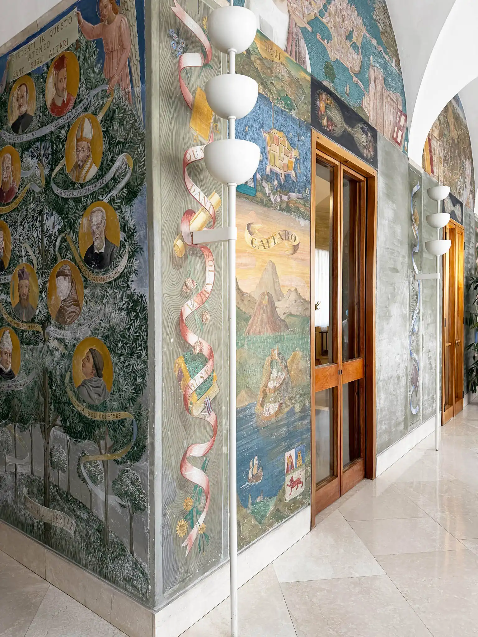 Coppia di luci da muro con corpo metallico bianco e parete decorata