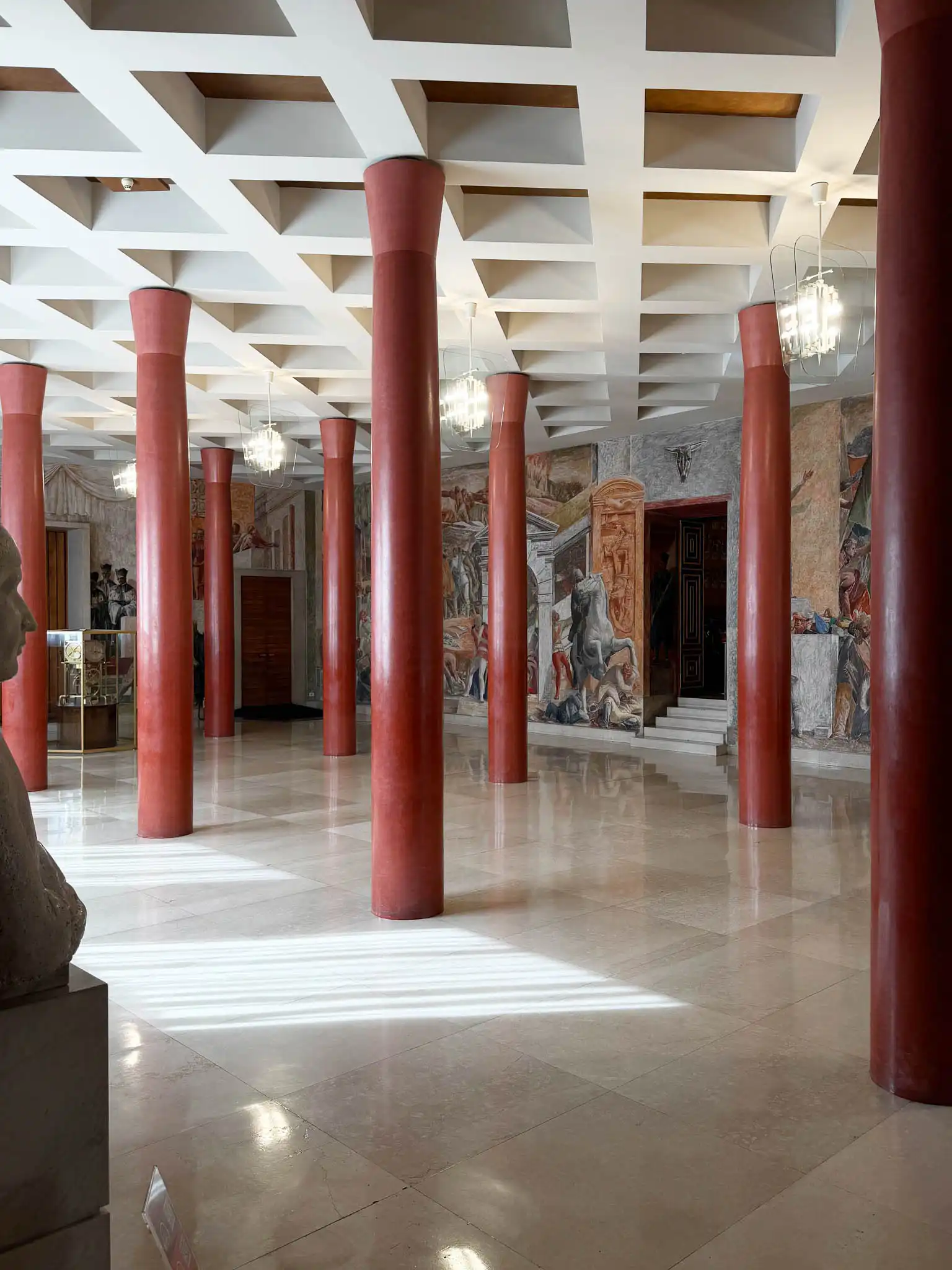 Atrio di passaggio con colonne rosse e soffitto a cassettoni