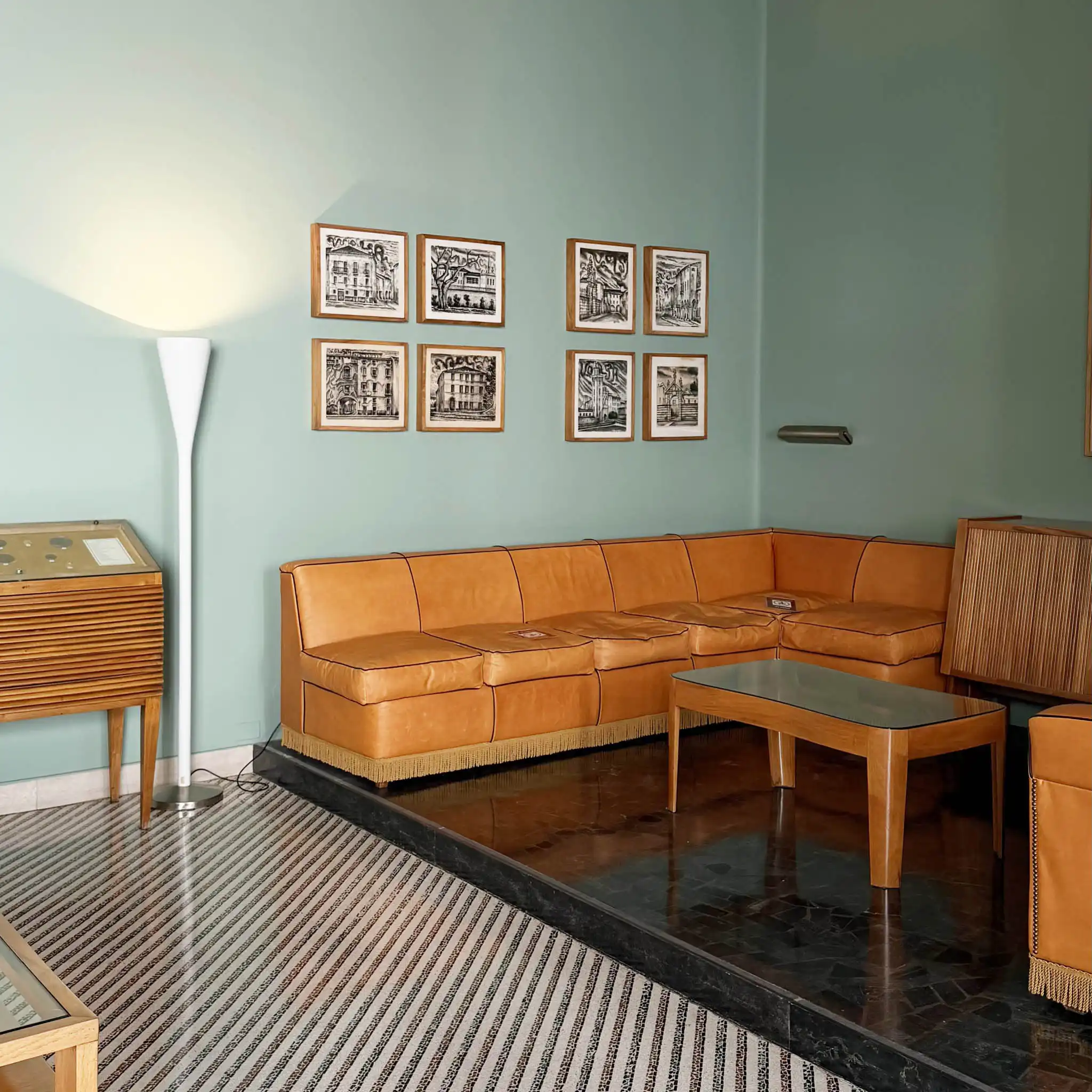 Divano color cognac con piantana da terra modernista