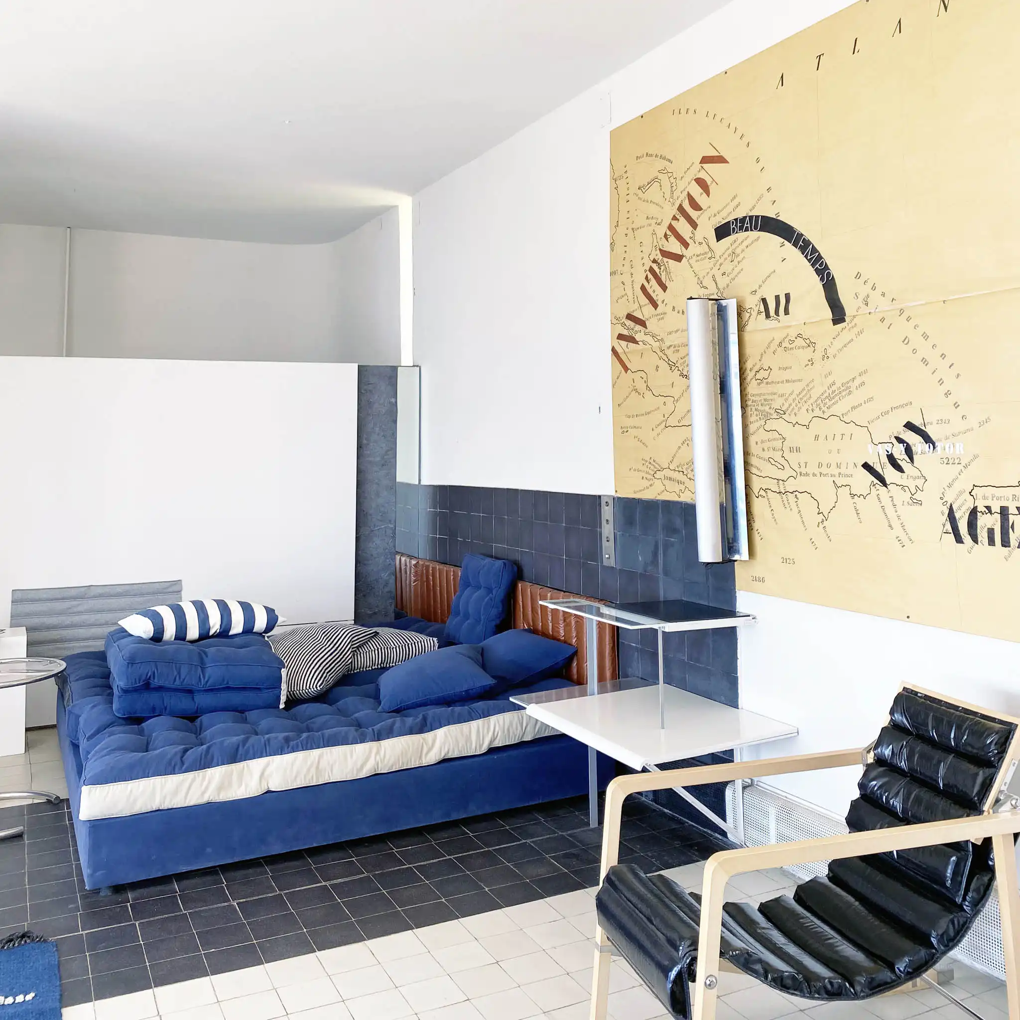 Open space con divano, poltrone e grande opera a parete