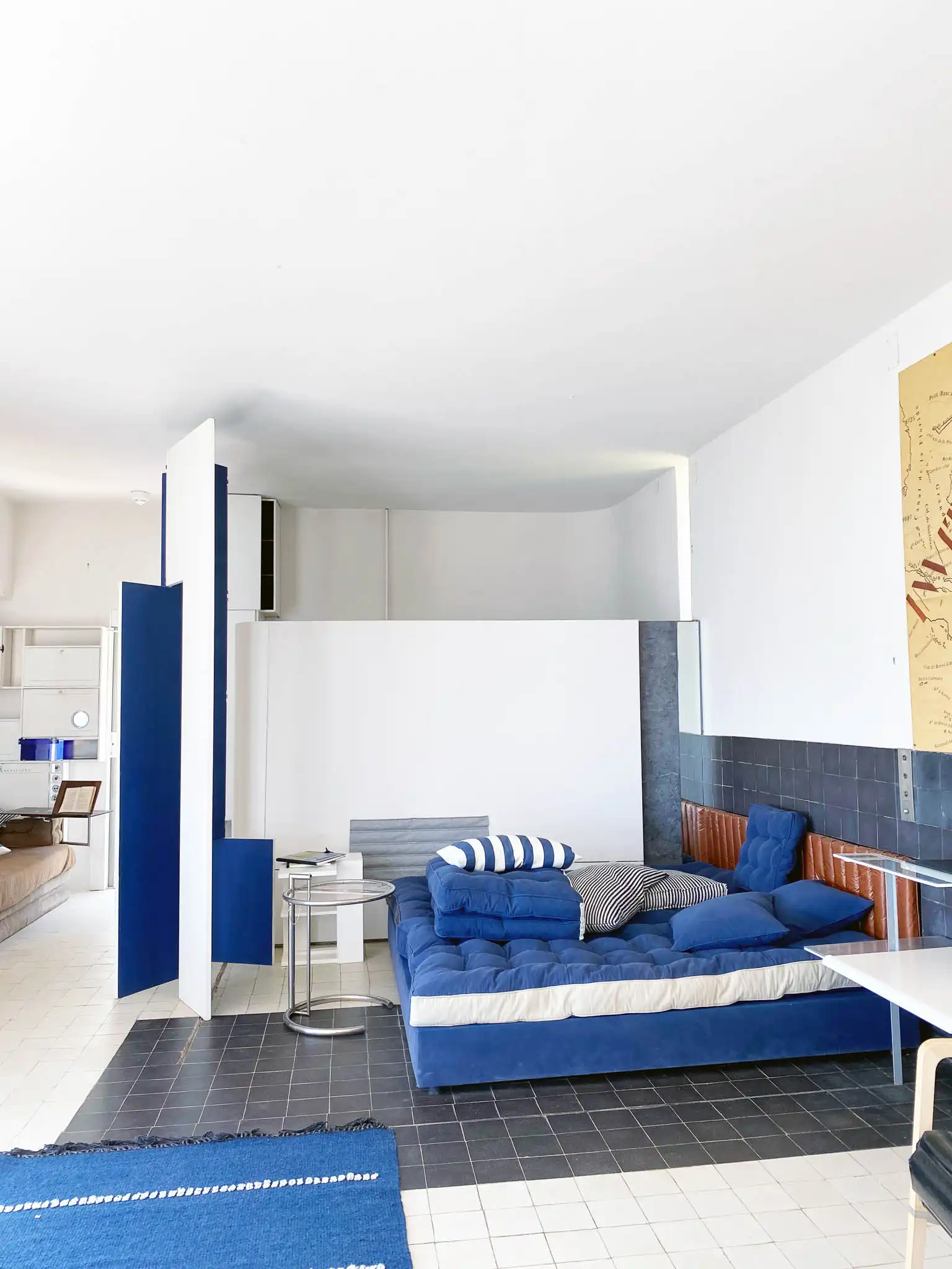 Open space con divano di colore blu mare e testata in pelle